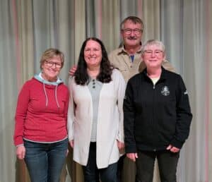 Drei Frauen und ein Mann posieren für ein Gruppenbild